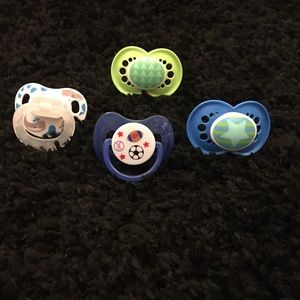 Four never used pacifiers. Boys.